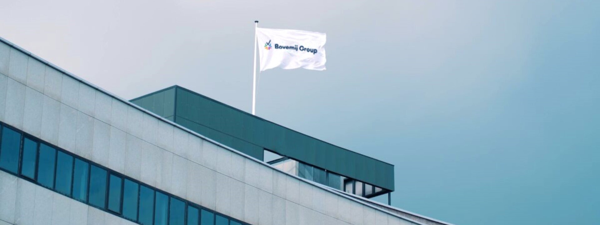 Het dak van het Bovemij pand met een Bovemij Group vlag.