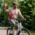 Man zit op een normale fiets en zwaait.